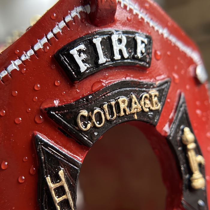 Close-up of the gold Maltese cross badge with FIRE COURAGE HONOR