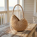 Hand-woven whelk handbag on weathered porch table at sunrise