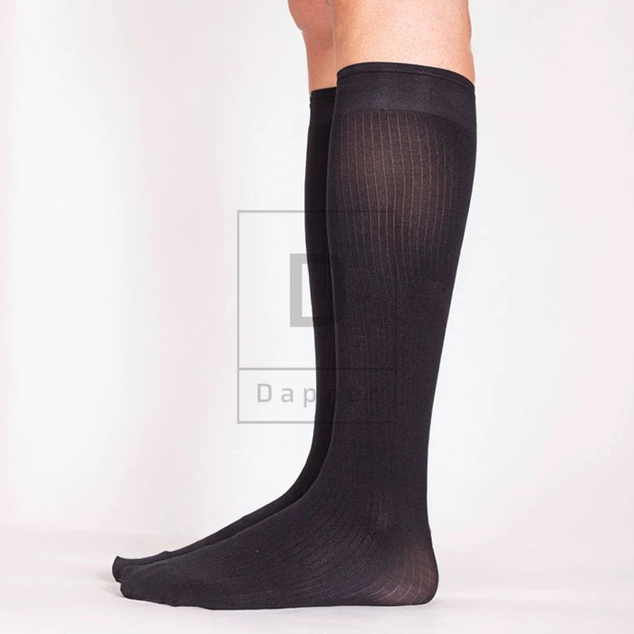 Side view of a black Striped Luxe dress sock worn on the leg, showing the fine striped knit, cuff, heel and toe